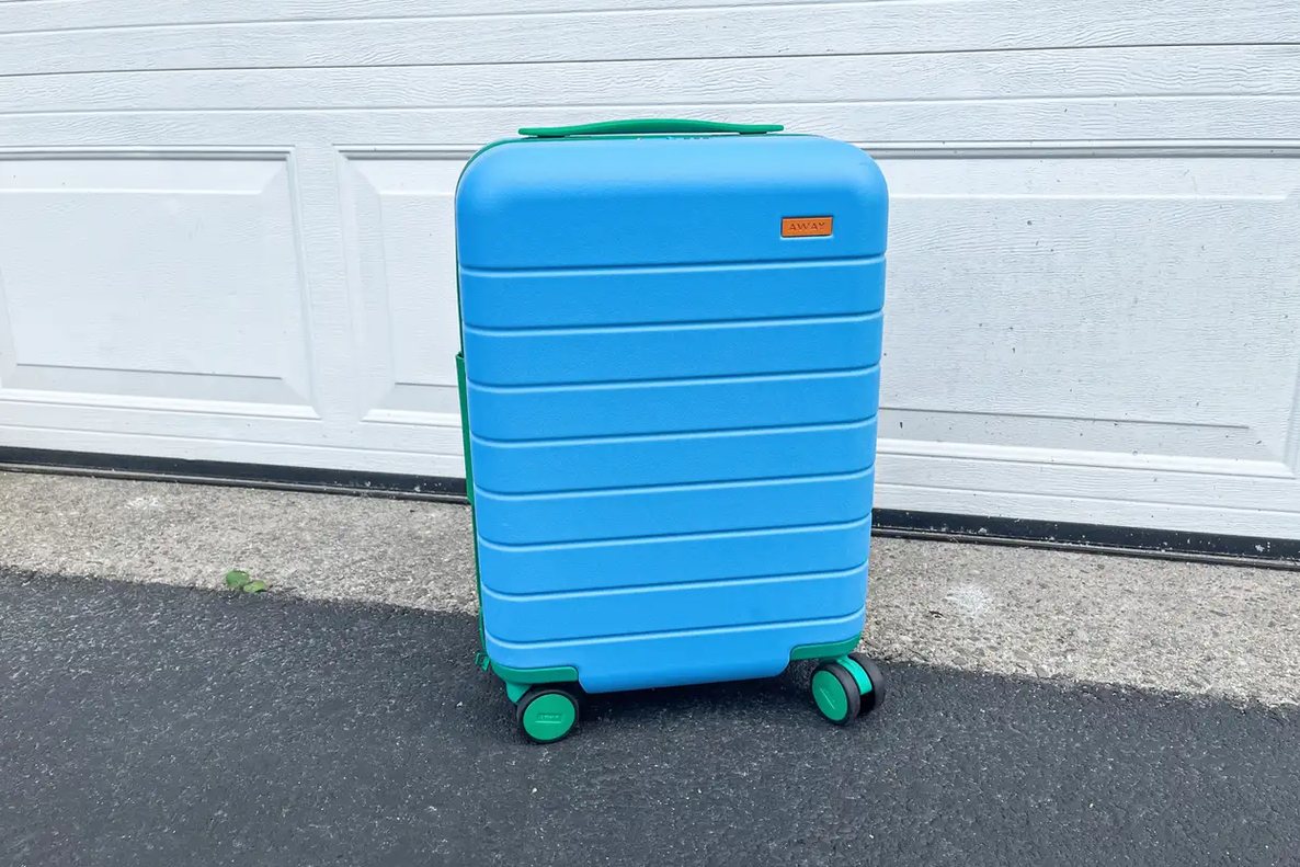 four carry-on suitcases lined up on a train platform, wheels visible