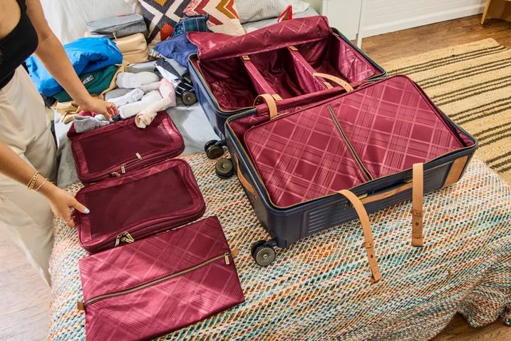 five carry-on cases lined up against a wall, wheels facing camera